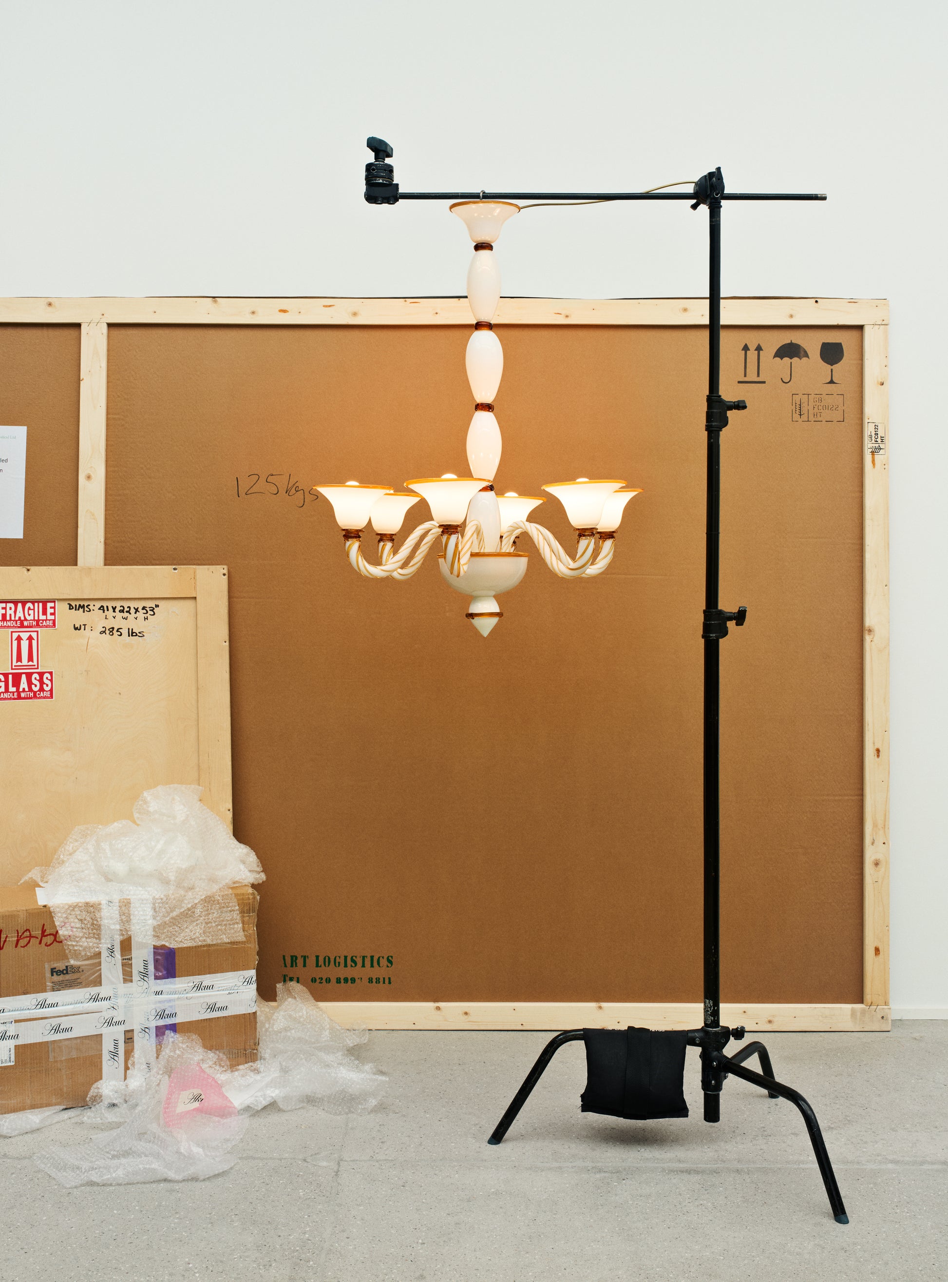 Long Murano glass chandelier in opal and amber hanging in atelier.