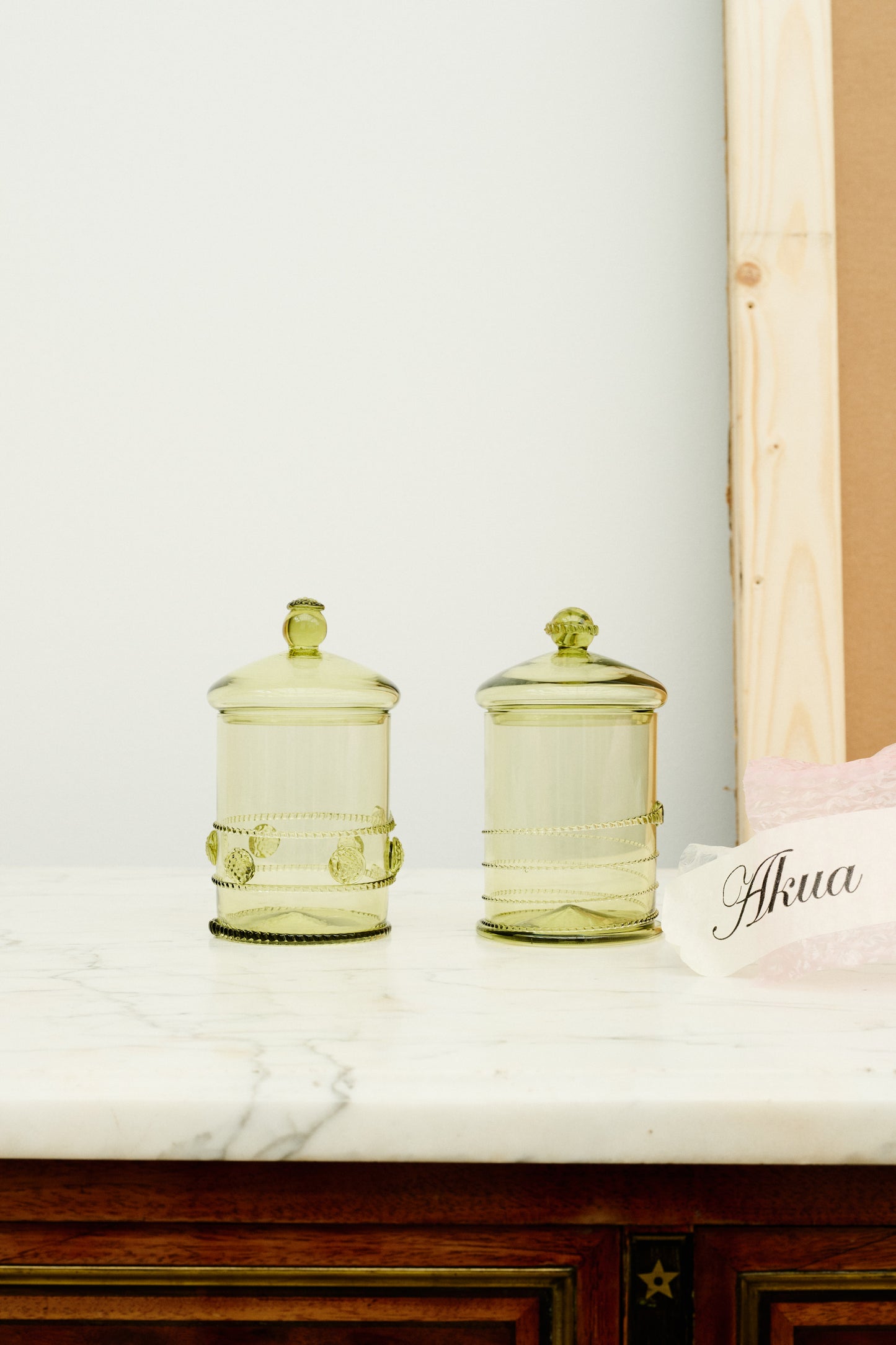 Two green glass bonbonnieres with swirl and dot details.