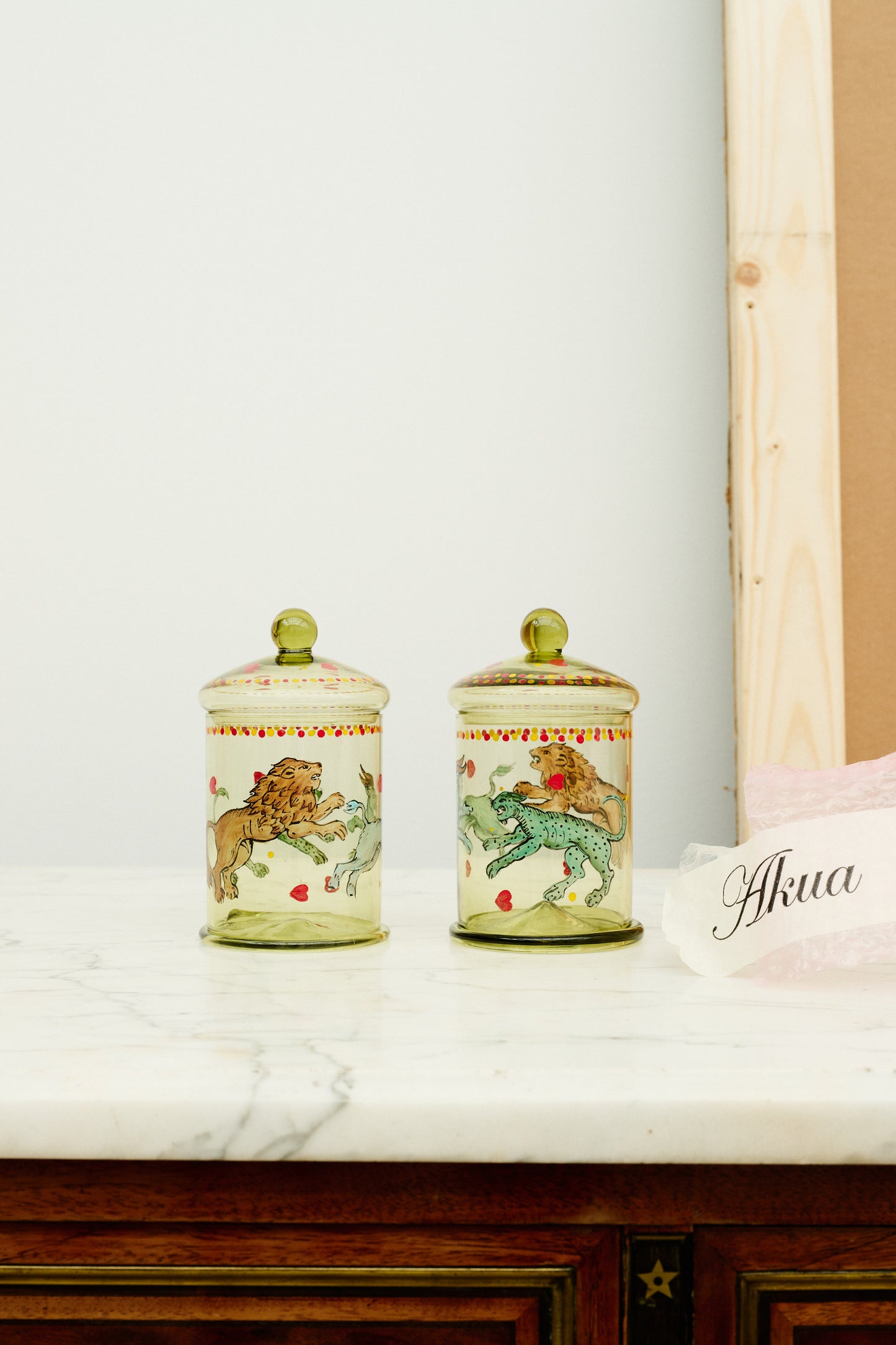 Two green glass bonbonnieres with hand painted animals.
