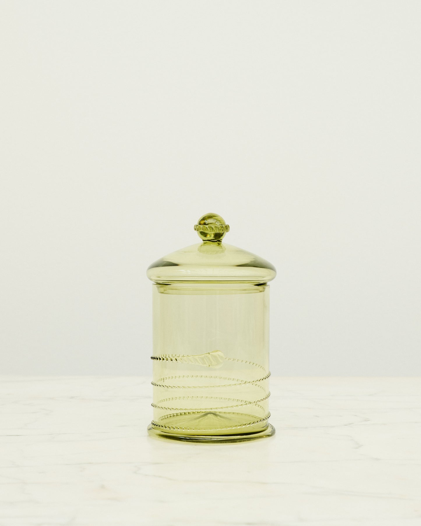 Green glass bonbonniere with swirl details.