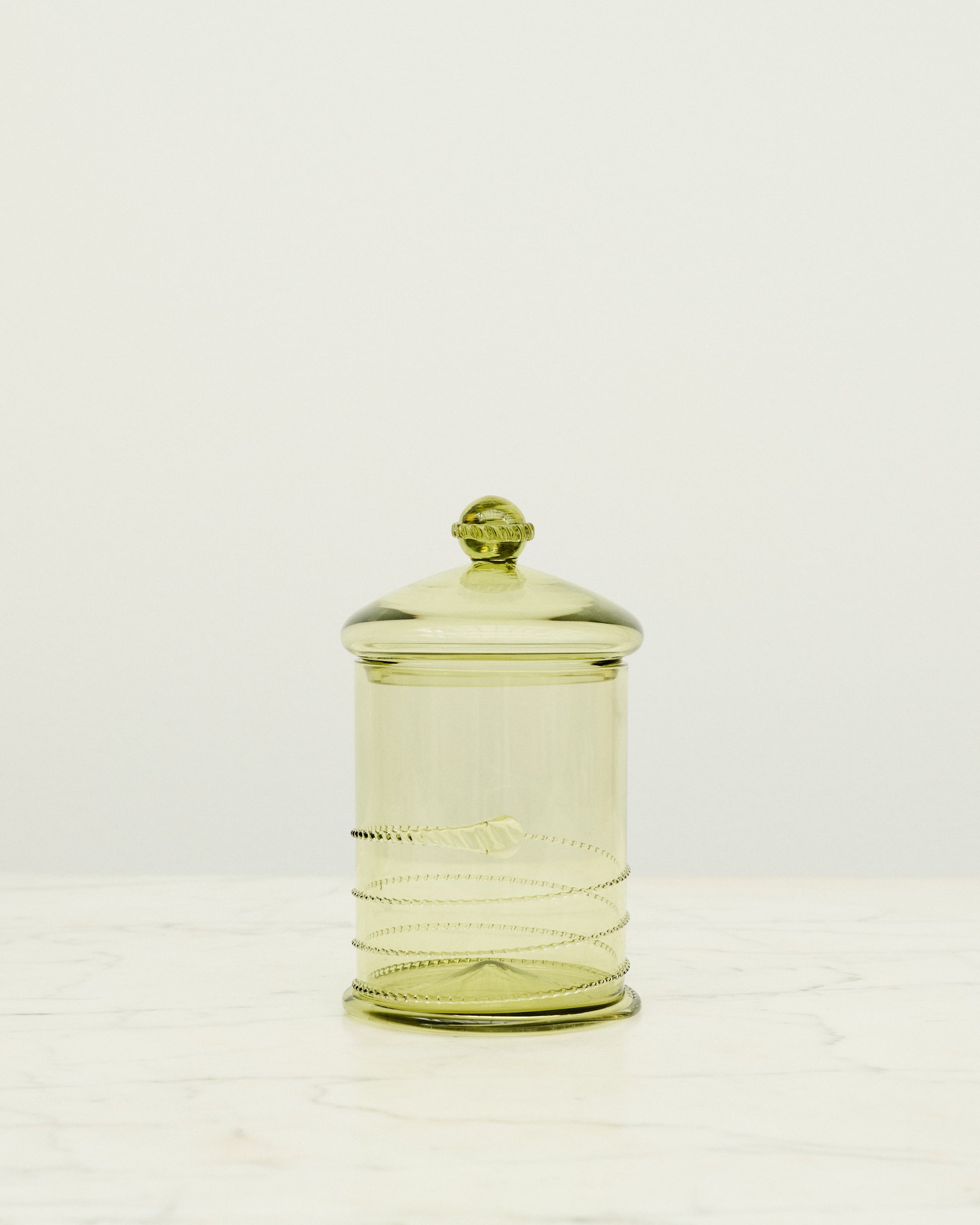 Green glass bonbonniere with swirl details.