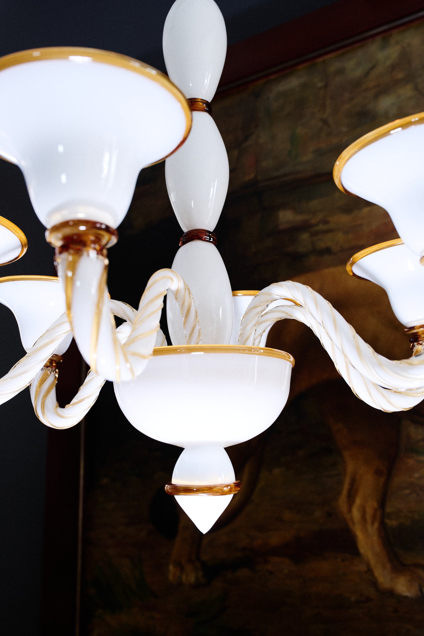 Long Murano glass chandelier in opal and amber hanging from ceiling.