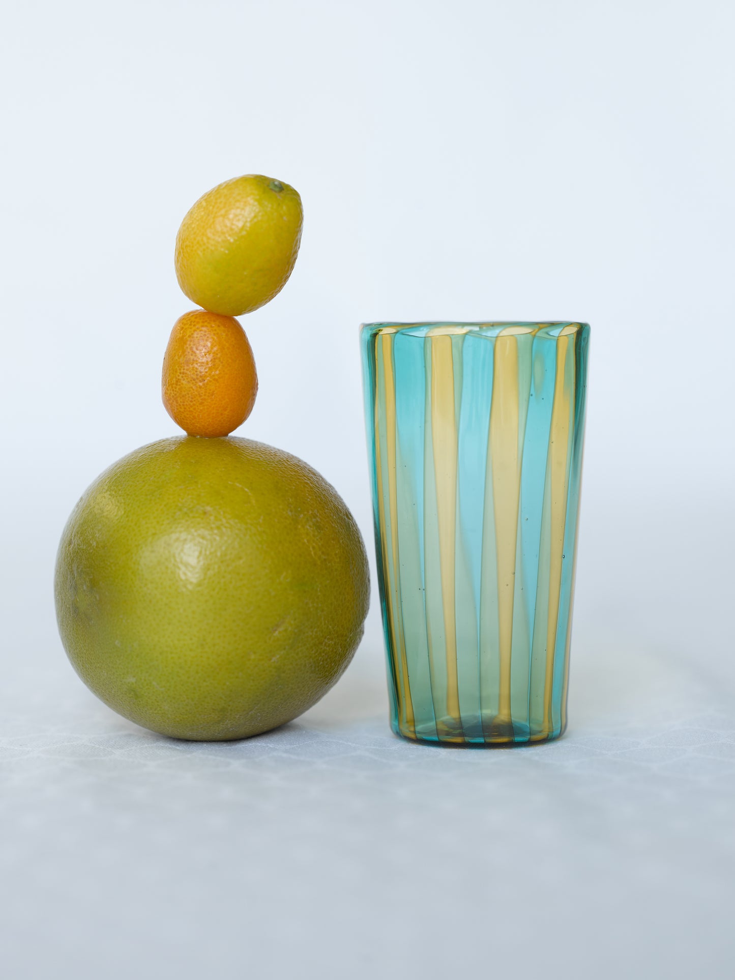 Small striped handmade Murano glass in blue and yellow with citrus fruits.
