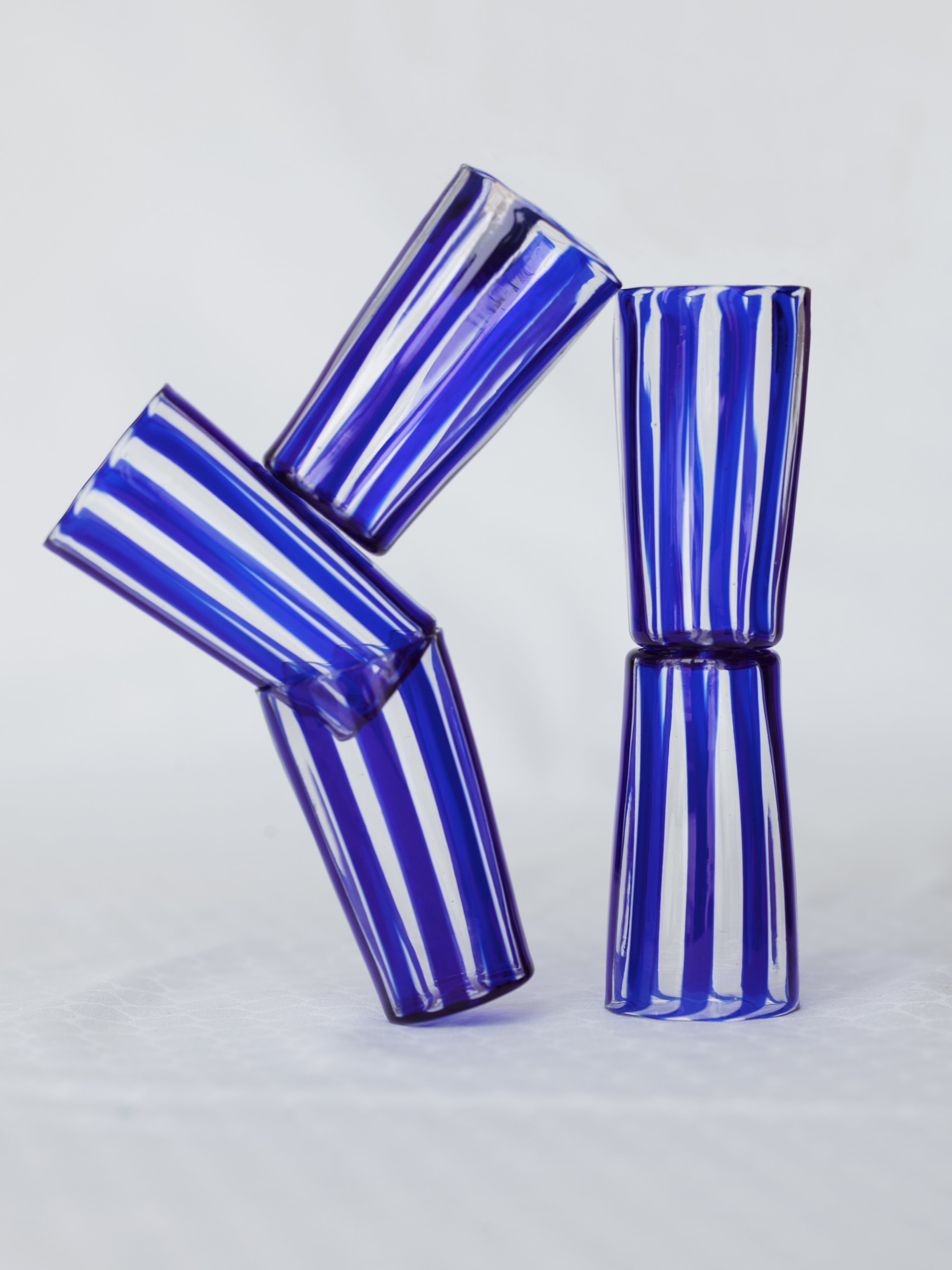 Multiple small striped handmade Murano glasses in blue.
