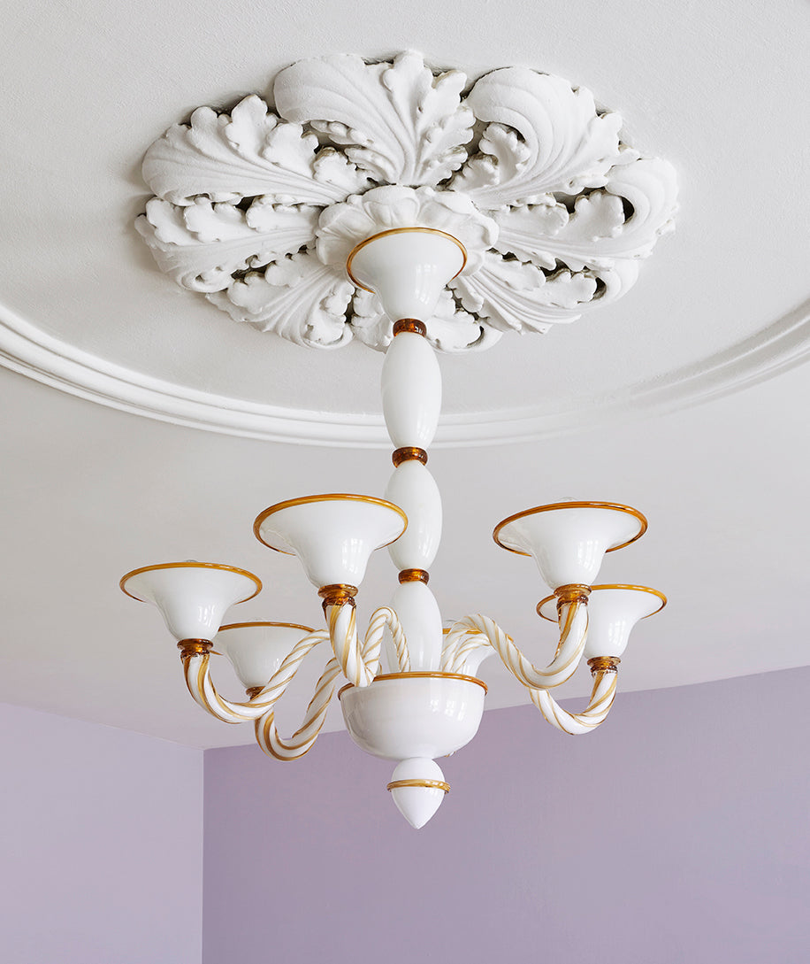 Short Murano glass chandelier hanging from ceiling in opal and amber.