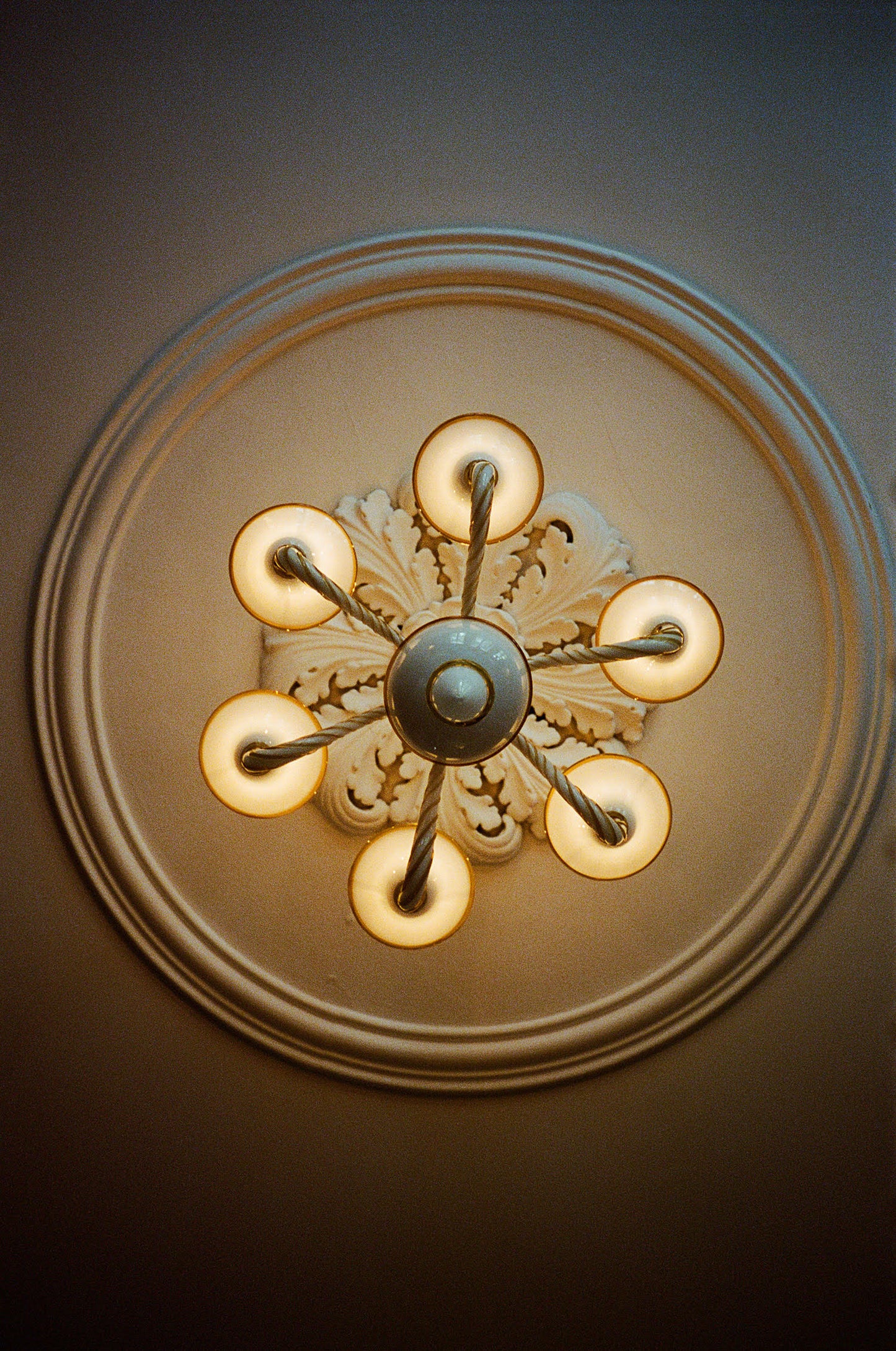 Short Murano glass chandelier in opal and amber hanging from ceiling.