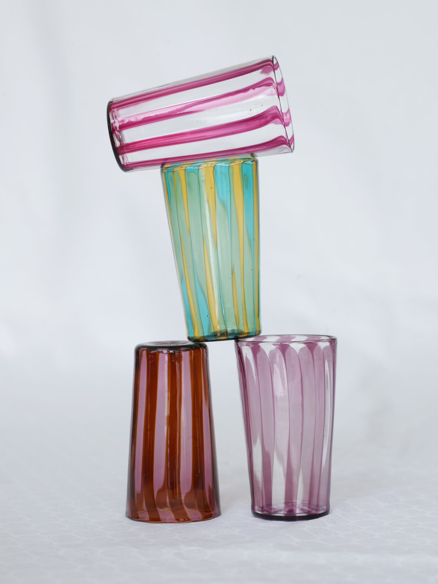 Multiple small striped handmade Murano glass in blue, yellow, brown and pink.